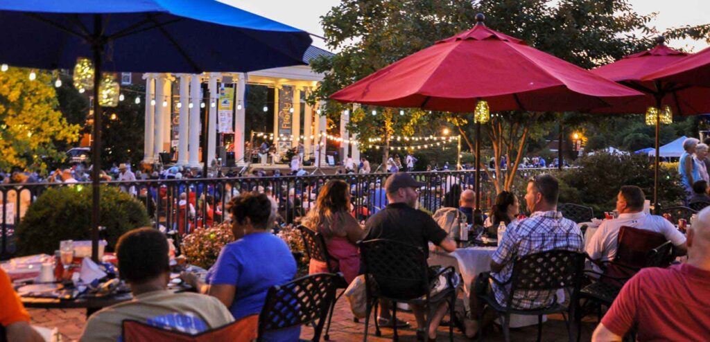 "People listen to live music in Madison Town Park."